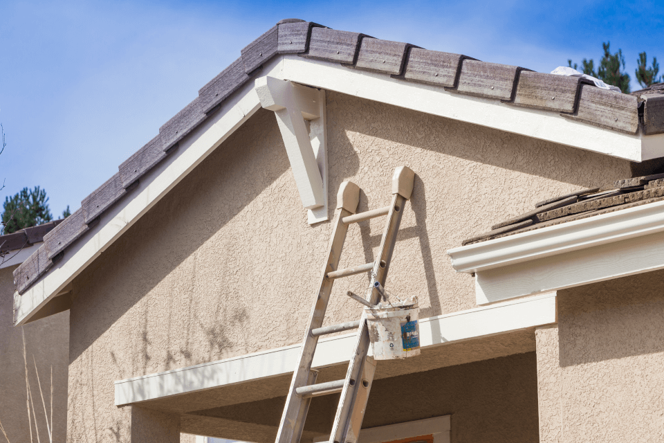 A house with a ladder propped against it, showcasing Benjamin Moore exterior paint.